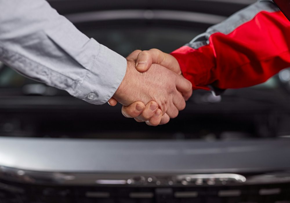 Customer and car mechanic shaking hands