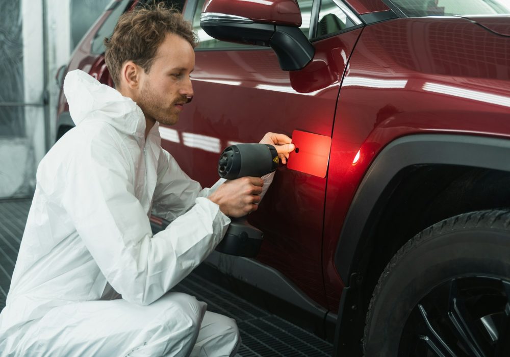 Professional auto painter matches car paint color with lamp and samples