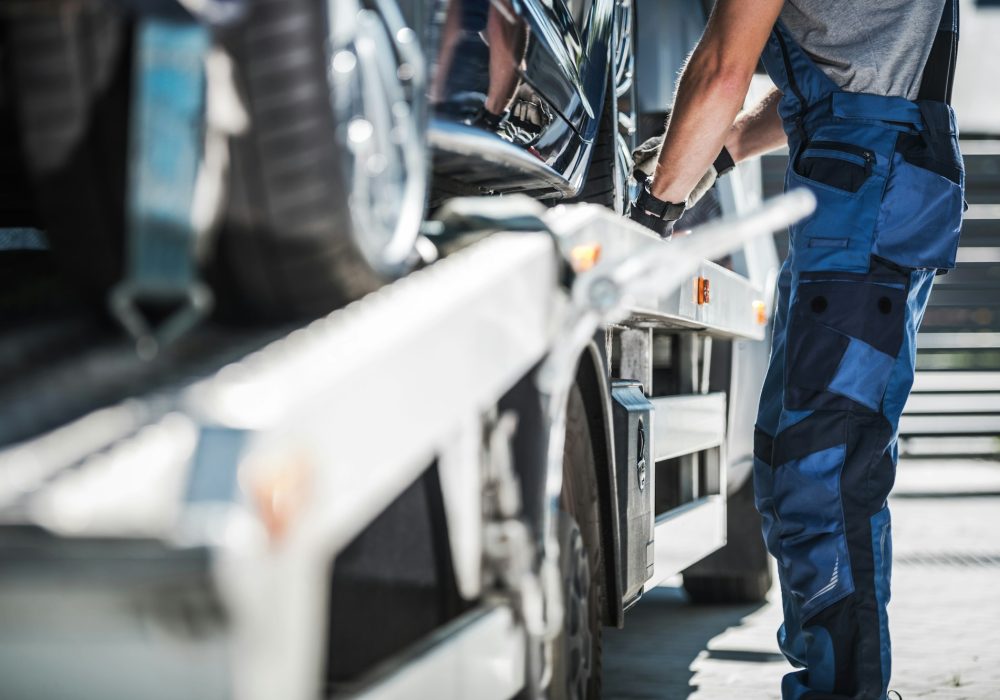 Worker Securing Car on a Towing Truck